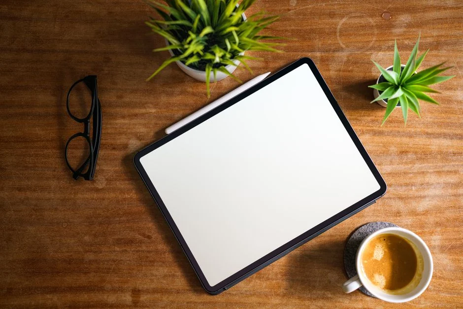 A tablet with a financial website open, alongside a white keyboard and mouse. Ideal for tech-theme stock images.