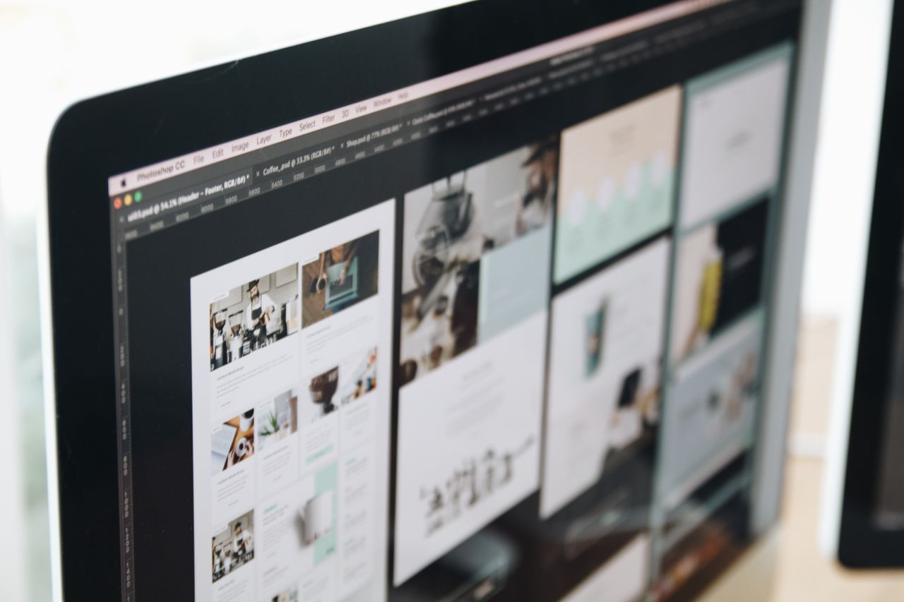 A contemporary computer monitor showing web design projects, highlighting creative imagery in a workspace.